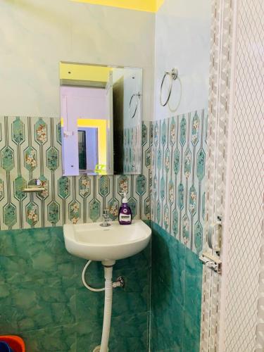 a bathroom with a sink and a mirror at Windchime9 in Guwahati