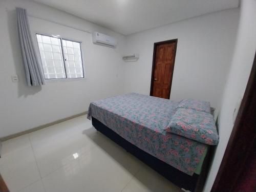 a small bedroom with a bed and a window at Espaço Brisa do Mar in Olinda
