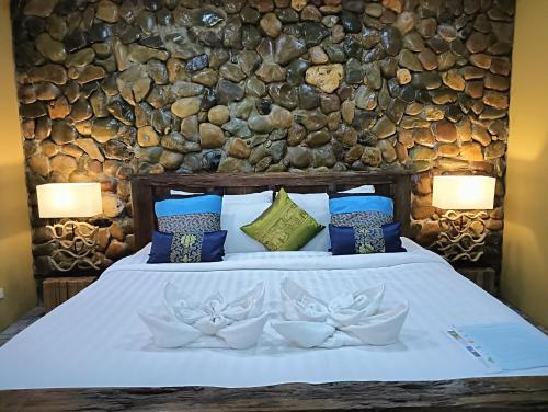 a bedroom with a bed with blue and green pillows at On The Mekong Resort in Luang Prabang
