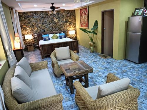 a living room with couches and chairs and a bed at On The Mekong Resort in Luang Prabang