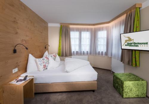 a hotel room with a bed and a projection screen at Hotel zum Hirschen Zell am See in Zell am See