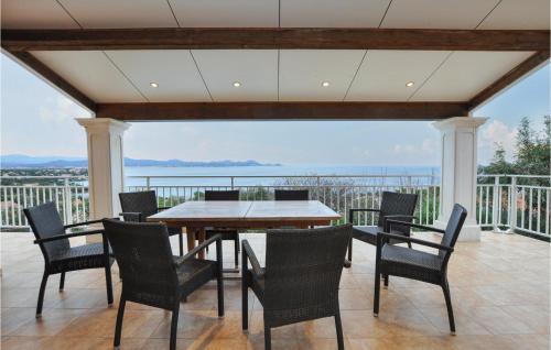 ein Esszimmer mit Tisch und Stühlen auf einem Balkon in der Unterkunft Gorgeous Home In Roquebrune-Sur-Argens in Saint-Peïre-sur-Mer