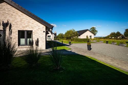 a brick building with a walkway next to a yard at Mein-Ostseeplätzchen Haus am Meer 6 in Niesgrau