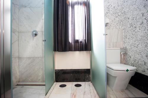 a bathroom with a shower and a toilet at Alhambra Suites in Madrid