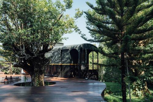 a building with a tree in a park at LA COCOTTE VILLA & FARM KHAO YAI in Nong Sarai
