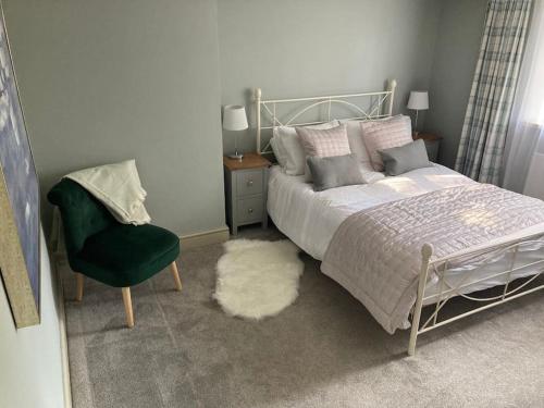 a bedroom with a bed and a chair at Luxury cottage with Hot Tub in Fenny Compton