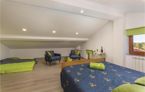 a bedroom with a bed and two chairs and a window at Apartment Gracisce 07 in Gržići