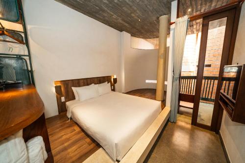 a small bedroom with a bed and a window at The Memory - Danang in Da Nang