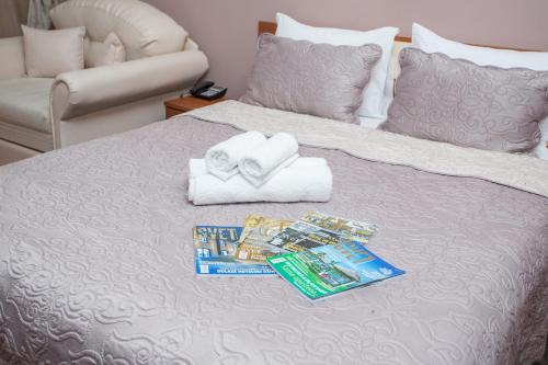 a bed with two towels and a pile of toothpaste at Sin-Kom Hotel Garni in Pirot