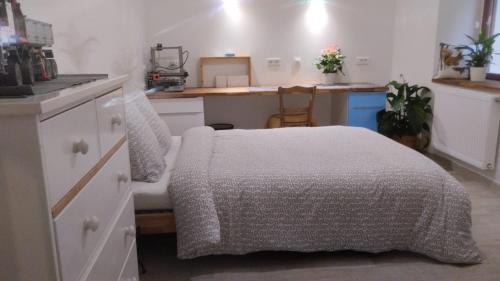 une petite chambre avec un lit et une cuisine dans l'établissement Chambre avec grand bureau sdb partagée, à Chavagne