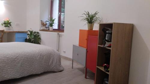 - une chambre avec un lit et une commode avec une télévision dans l'établissement Chambre avec grand bureau sdb partagée, à Chavagne