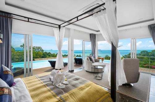 a bedroom with a bed and a view of the ocean at MM Villa Koh Samui in Amphoe Koh Samui