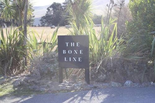 a sign that says the booze line on the side of a road at Olive Grove Cabin Waipara in Waipara