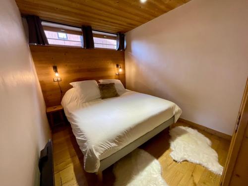 une petite chambre avec un lit et une fenêtre dans l'établissement Le Refuge du Val Arly, à Praz-sur-Arly