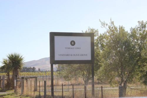 a sign for a wine tree winery compound at Olive Grove Cabin Waipara in Waipara