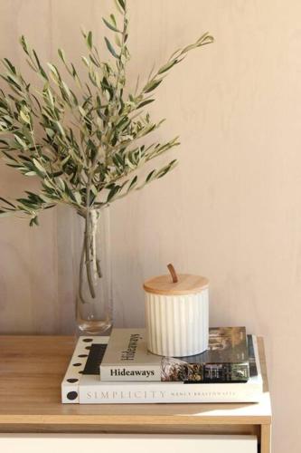 a vase of flowers sitting on top of a table at Olive Grove Cabin Waipara in Waipara