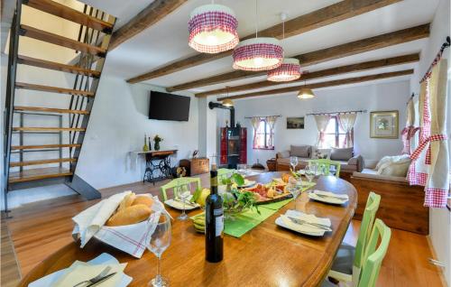 a dining room with a table with a bottle of wine at Awesome Home In Breznicki Hum in Donje Makojišće