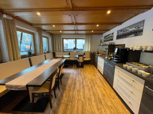 een restaurant met een lange tafel en een keuken bij Haus Tanja in Sölden