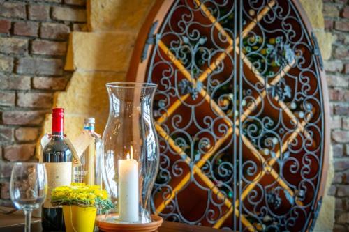a table with a glass vase and bottles of wine at Hostellerie Valckenborgh - Lodging Only in Valkenburg