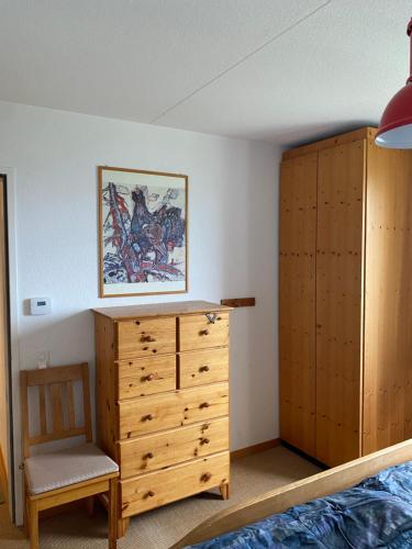 a bedroom with a wooden cabinet and a dresser at Hoch über dem Rheintal in Brigels