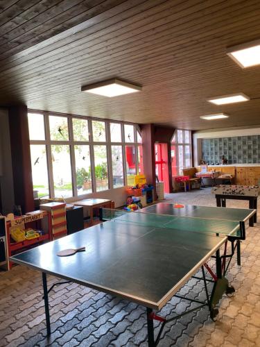 a large ping pong table in a room with windows at Hoch über dem Rheintal in Brigels