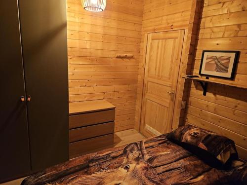 a bedroom with a bed in a log cabin at Casa De Los Ciervos in Stekene