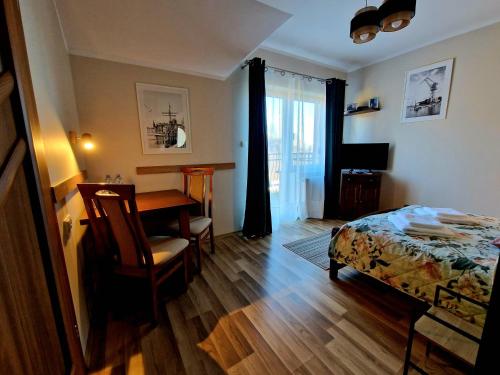 a bedroom with a desk and a bed and a table at Willa Bliska in Gdańsk