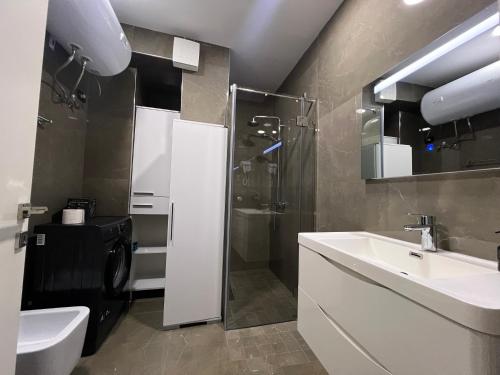 a bathroom with a sink and a shower and a toilet at Downtown Grand Comfort in Tirana