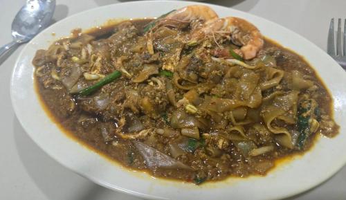 a white plate of food on a table at Captain's Cabin Resort - Naval Heritage (Swimming Pool) in Kota Bharu