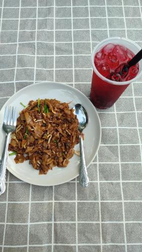 a plate of food on a table with a fork and spoon at Captain's Cabin Resort - Naval Heritage (Swimming Pool) in Kota Bharu