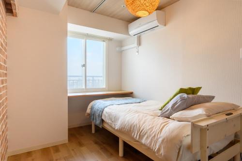 a bedroom with a bed and a window at Nakajima Park stay AMS tower 27F Panoramic view of Sapporo city in Sapporo