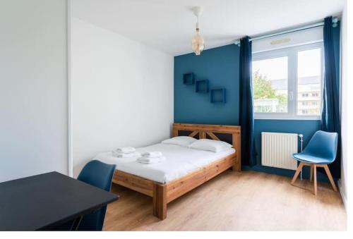 une chambre avec un lit et un mur bleu dans l'établissement La Tanière de la Loire 3Chambres, à Nantes