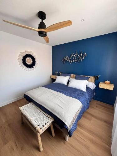une chambre avec un lit et un ventilateur de plafond dans l'établissement L'Escale Maison de caractère quartier Saint Michel, à Les Sables-dʼOlonne