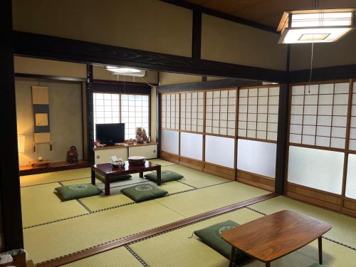 Cette chambre dispose d'une table et de tapis verts au sol. dans l'établissement みんなのひみつきち YuToRi 遊人里, à Higashihiroshima