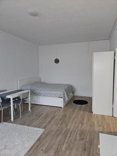 a white bedroom with a bed and a table at City Base Dortmund in Dortmund