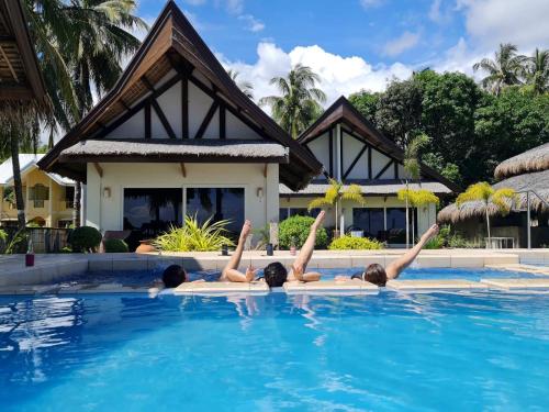 a group of people laying in a swimming pool at Solaj Dive and Beach Resort Zamboanguita in Zamboanguita