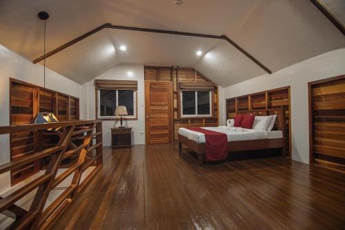 a bedroom with a bed and wooden floors and a staircase at Solaj Dive and Beach Resort Zamboanguita in Zamboanguita