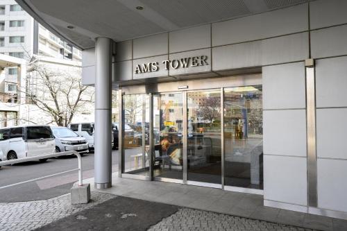 aiss tower building with a sign on the side of it at Nakajima Park stay AMS tower 27F Panoramic view of Sapporo city in Sapporo