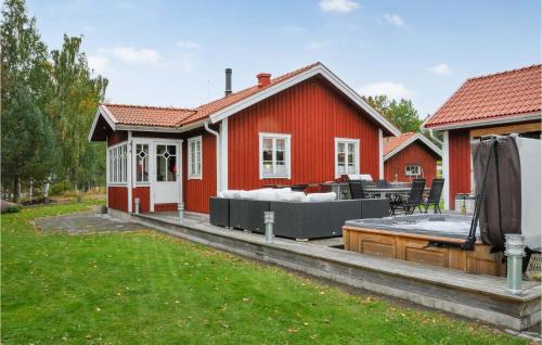 a red house with a deck and a hot tub at Stunning Home In Karlstad With Sauna in Karlstad