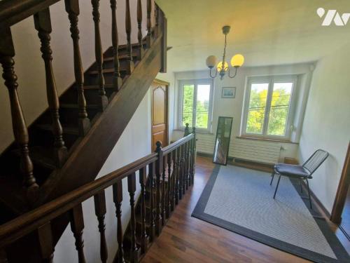 a hallway with a staircase with a chair and a window at Les Hauts de Proisy in Proisy
