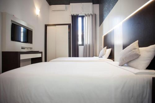a hotel room with two beds and a television at Alhambra Suites in Madrid