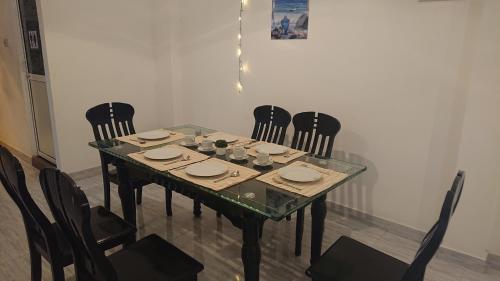 a dining room table with chairs and a glass table top at CANAAN MUSIC Hotel in Moratuwa