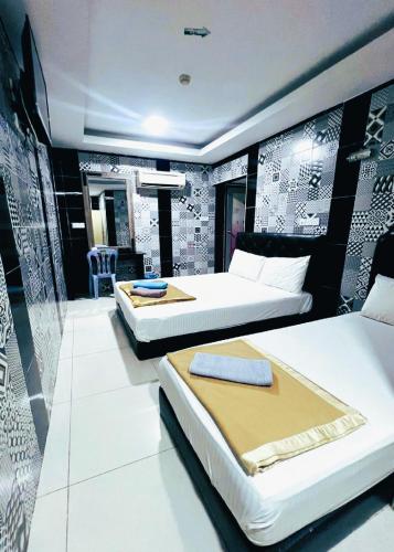 a hotel room with two beds and a table at ARK Ampang Tesco Hotel in Kuala Lumpur