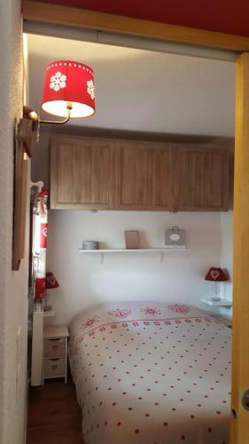 une chambre avec un lit et une lampe rouge dans l'établissement Charmant Studio La Toussuire, à La Toussuire