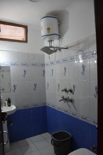 a blue and white bathroom with a toilet and a sink at Hotel Sunrise in Chandīgarh