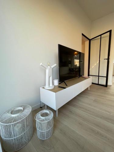 a living room with a dresser and two stools at Pand 43 in Diksmuide