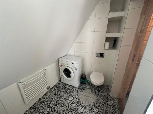 a small bathroom with a washing machine and a toilet at Apartamenty u Mocarnego in Szaflary