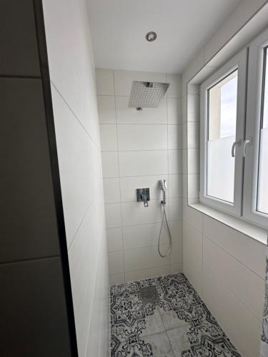 a bathroom with a shower with a window at Apartamenty u Mocarnego in Szaflary