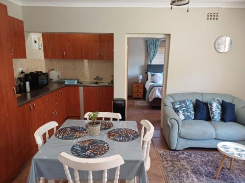 a kitchen and living room with a table and a couch at Susanna's Self catering 2 bedroom apartment in Kimberley