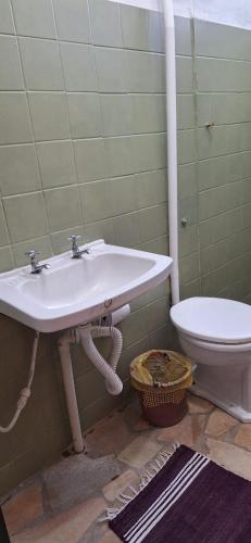 a bathroom with a sink and a toilet at Paradise Hospedaria São Thomé in São Thomé das Letras